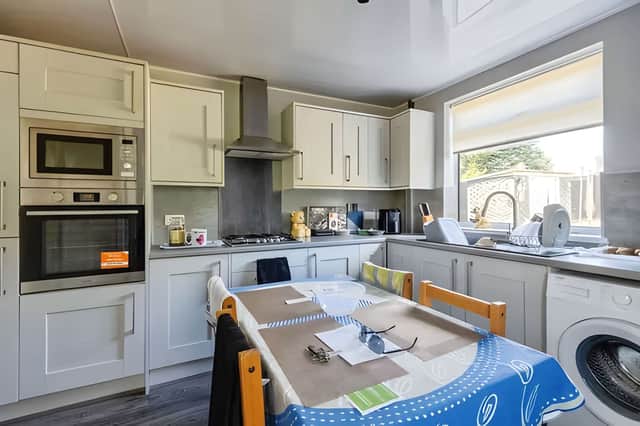 The contemporary kitchen combines practical workspace with modern styling for everyday family living.