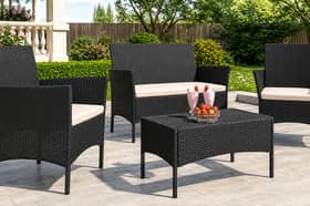 The four-seater rattan garden furniture set includes a sofa, two armchairs and a matching table