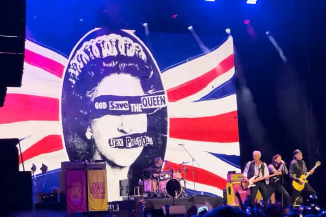 Sex Pistols flying the flag for punk rebellion with their iconic God Save the Queen imagery towering over the stage at Scarborough Open Air Theatre.