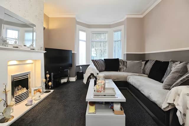 A bright bay window and character fireplace give the main reception room a welcoming feel while celebrating the property's Victorian heritage