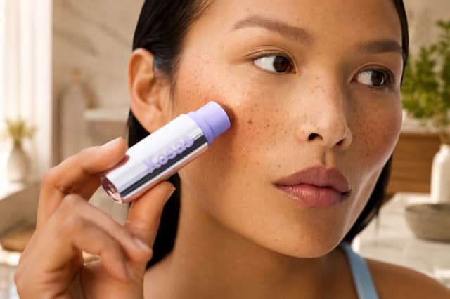 The Kosas Impressionist Multistick is applied directly to the cheeks, blending effortlessly to create a fresh, natural-looking flush with a dewy finish.