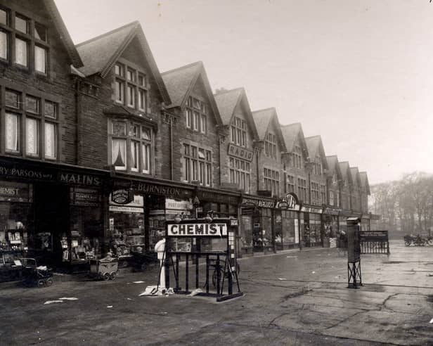 Parade of shops on Street Lane in December 1932. On the left no 59 are Harry Parsons, chemist and Raymond Malins, ironmonger, sharing a shop entrance. To the right, no 61 is Fred Burniston newsagent and Post office. Babies in their prams are outside the shops. An electric sign for the chemist is on the pavement.