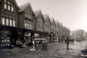 Parade of shops on Street Lane in December 1932. On the left no 59 are Harry Parsons, chemist and Raymond Malins, ironmonger, sharing a shop entrance. To the right, no 61 is Fred Burniston newsagent and Post office. Babies in their prams are outside the shops. An electric sign for the chemist is on the pavement.
