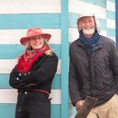 Lisa Lindqvist and Shane Green standing in front of a blue-striped beach hut