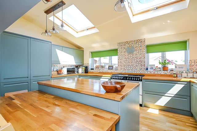A heritage green shaker-style kitchen, solid oak worktops and a substantial island create the centrepiece of this bright open-plan living space.