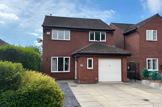 The detached Colton home combines a generous driveway, gated side access and an integrated garage, creating a practical approach to a property overlooking mature woodland.