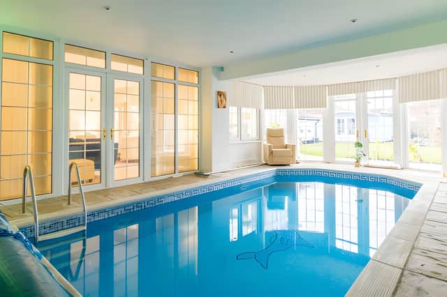 The home has a heated indoor swimming pool, complete with adjacent sauna cabin and gym area