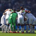 The Leeds United players huddle at the Amex.