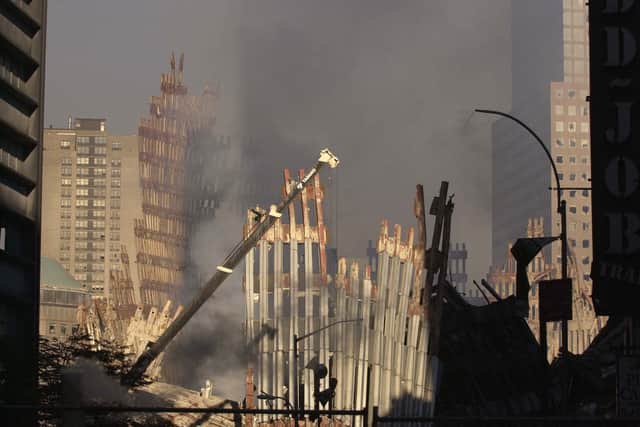The skeletal remains of the World Trade Centre  seen through dust and smoke at Ground Zero as seen from lower Broadway. 