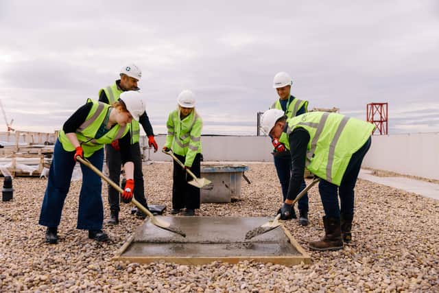 Students were invited to pour concrete at the top of the Domo development