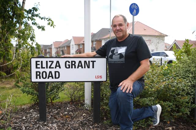 Grandson Ron Grant next to the Eliza Grant Road sign