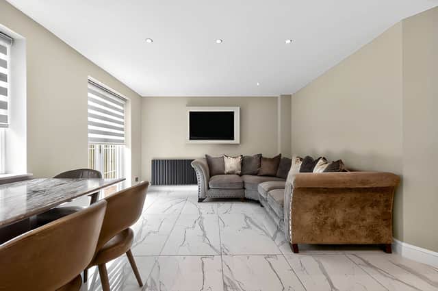 The inviting lounge features a striking media wall, while a separate TV room or playroom provides another versatile reception space