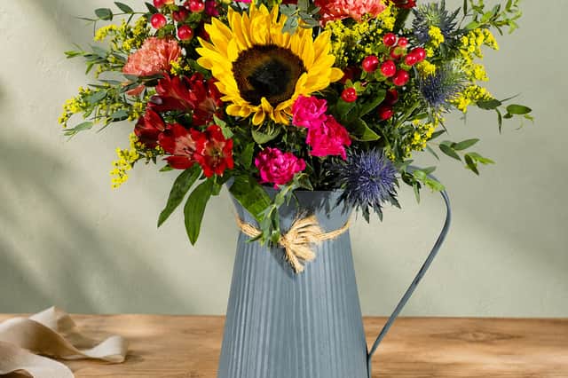Bunches’ Golden Woodland bouquet features a bold sunflower with rich red, pink and yellow blooms for a vibrant autumn display.
