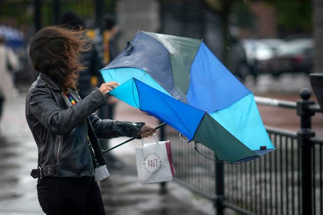 People brave the first rain and wind of Storm Agnes as it approaches the UK in September 2023.