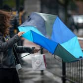 People brave the first rain and wind of Storm Agnes as it approaches the UK in September 2023.