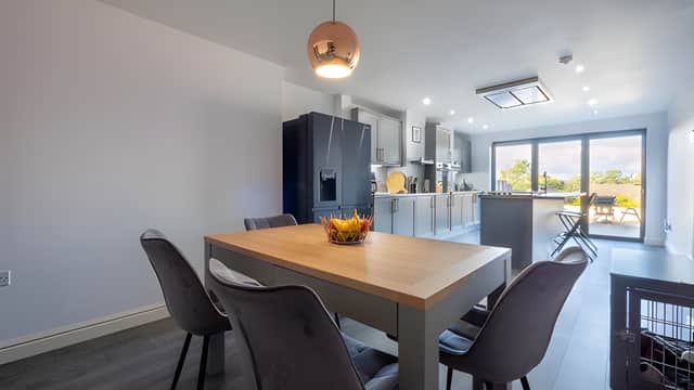 The large basement kitchen and dining area features bifold doors leading to the patio, creating a bright and versatile part of the house