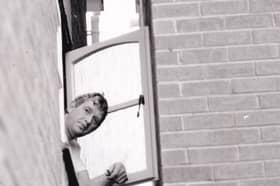 John Cook tries to open his landing window.