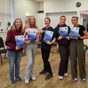 Helen Underwood with learners from a recent Paediatric First Aid course holding the newly printed fifth edition of The ABCDE of First Aid
