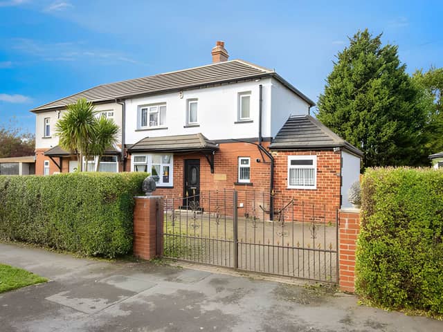 Double iron gates open onto a generous driveway with space for up to four cars, while the gated front garden adds to the property's established appeal