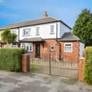 Double iron gates open onto a generous driveway with space for up to four cars, while the gated front garden adds to the property's established appeal