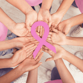 People holding a pink ribbon together to mark Wear It Pink Day 2026