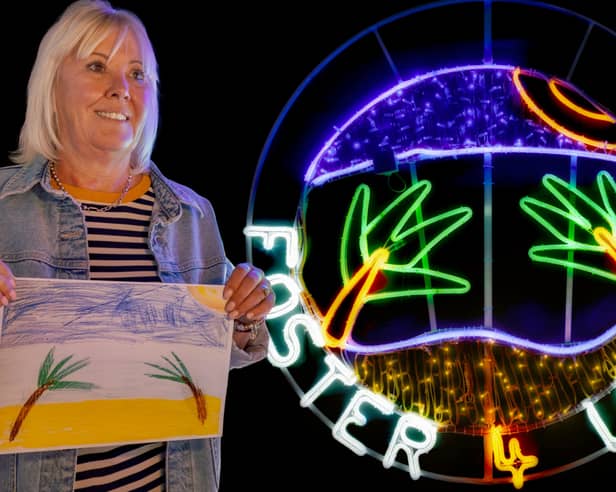 Foster carer Marie Procter with the neon light display created from a child's holiday drawing for Light Night Leeds