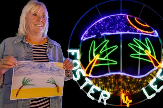Foster carer Marie Procter with the neon light display created from a child's holiday drawing for Light Night Leeds