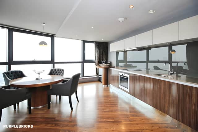 Gloss-finish cabinetry, solid worktops and integrated appliances give the contemporary kitchen a streamlined look