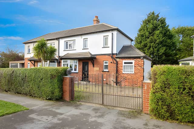 Gated double iron gates open onto a driveway with space for up to four cars at this refurbished Broadway home.