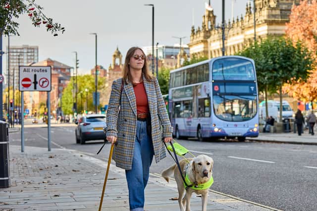 Chloe and guid dog Dezzie walk through Leeds city centre