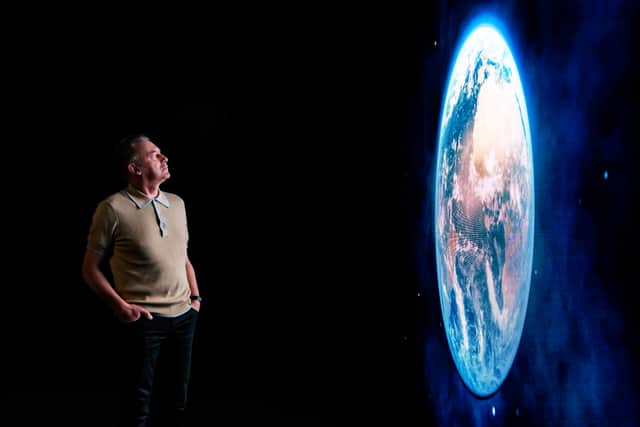 Chris Packham looking at image of Earth