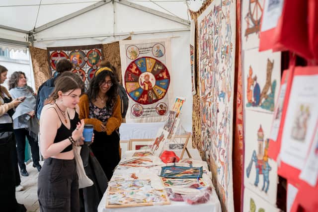 Attendees browse medieval-inspired artwork and textiles.
