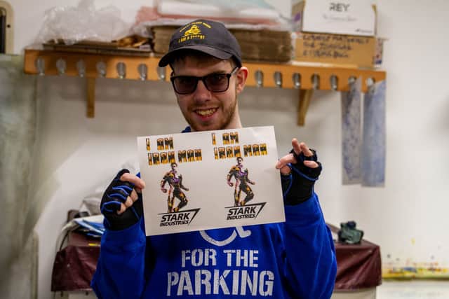 Pyramid artist, Alfie, holds up his screen-printed artwork.