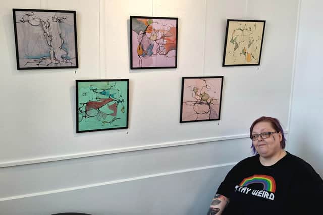 Artist Doll with artwork from their 'Take a Load Off' exhibition