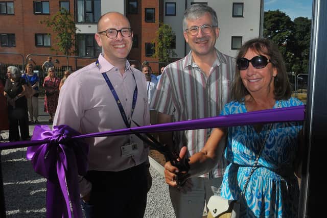 Marcia Brown cuts the ribbon to open LJHA’s new affordable homes development, watched by the association’s Director of Operations Craig Simons (left) and Chair of the Board Andrew Pliener