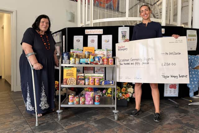 Community Pantry Chair Olivia Rowley receives the donation from Taylor Wimpey’s Tarnya Chadwick.