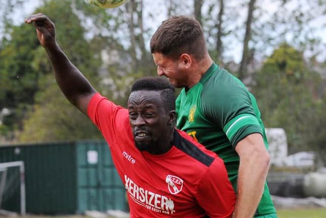 Ryan Grant of Hunslet Club beats Gibril Bojang of Horbury Town to the ball.