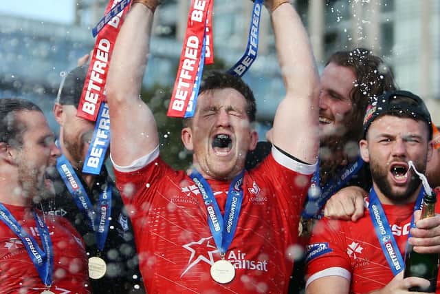 Toronto Wolfpack captain Josh McCrone lifts the Betfred Championship trophy after his side's victory over Featherstone.