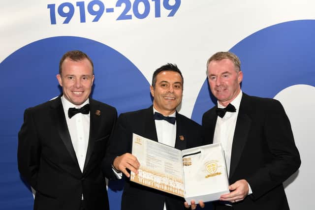 John Sheridan, right, being presented with a personalised replica of the Leeds United centenary kit by owner Andrea Radrizzani, centre, and managing director Angus Kinnear (Pic: Jonathan Gawthorpe)