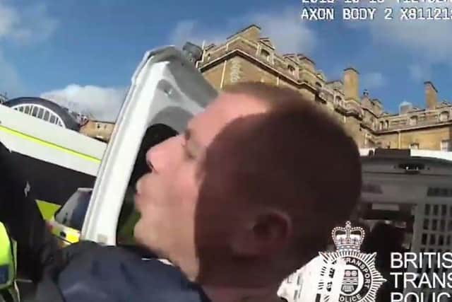 Jamie Glover was caught on video spitting at the officer from just inches away (Photo and video: British Transport Police).