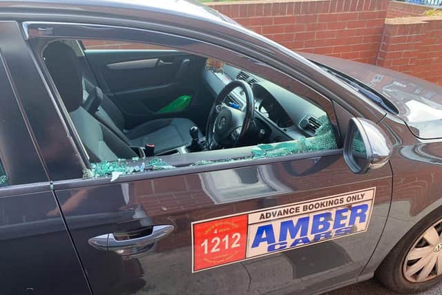 The damage caused to a taxi driver's window after a stone was thrown at the vehicle by youths