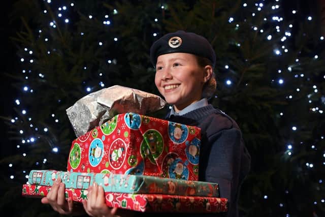 Lilli Pearson, 12, from 168 City of Leeds Air Training Corps, puts donated presents under the tree during last year's YEP Christmas Carol Service. Picture: Jonathan Gawthorpe