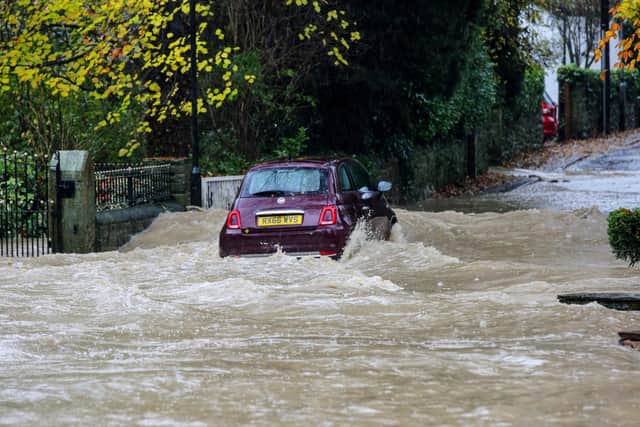 Vehicles try to pass deep flood water as it rises in the village of Whiston near Sheffield (Photo: Tom Maddick / SWNS)