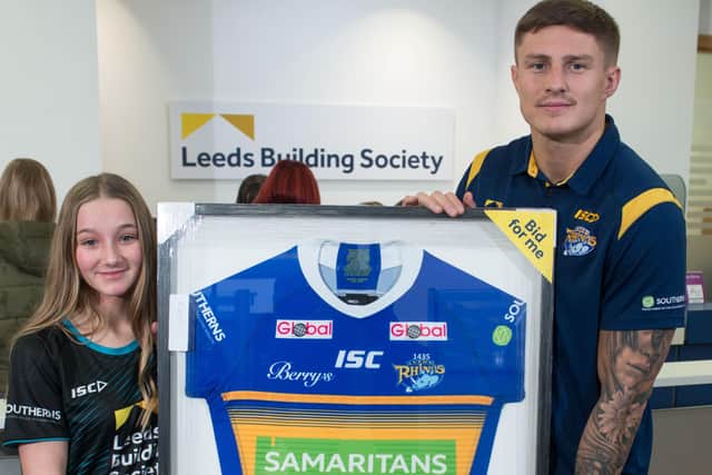 Liam Sutcliffe presents signed match shirts to the winners of the recent charity auction in aid of the Samaritans at Leeds Building Society's head office in Leeds.