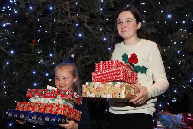 Emily Young (7) and Niamh Walton-Foulds (12), put presnts under the tree.