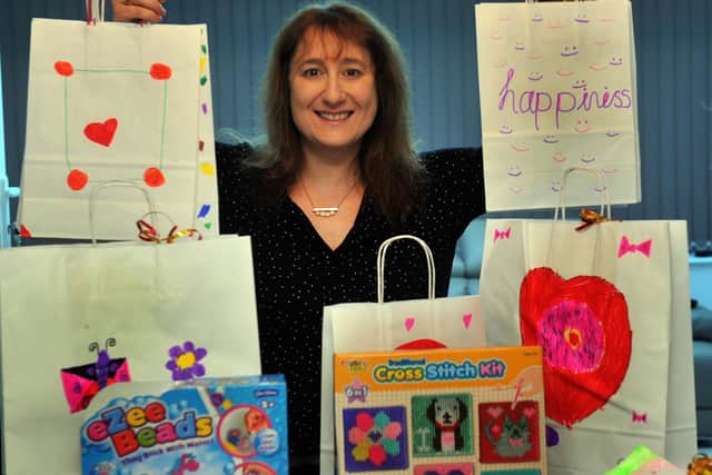 Claire Baskind, with some of the items donated as part of Christmas Gifts for Poorly Kids, which will go to children who find themselves staying in hospital this festive season. Image: Gary Longbottom.