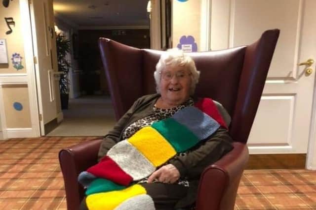 88-year-old Brenda Horsefall with one of 174 scarves she has knitted for her friends in a Leeds care home