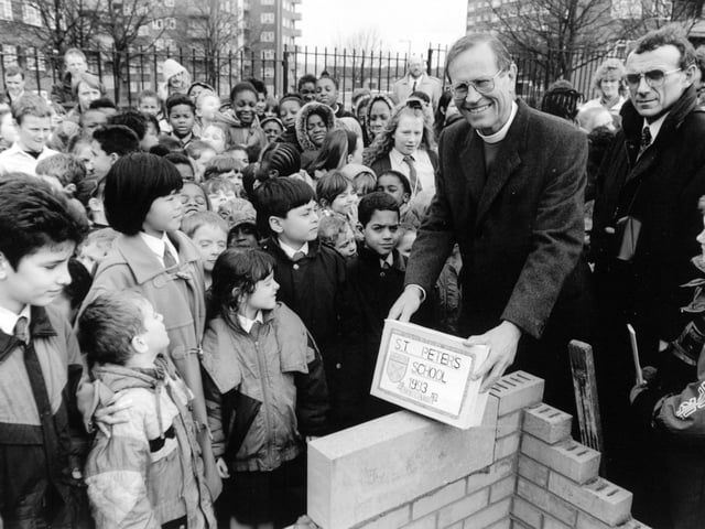 The Bishop of Ripon, the Right Reverend David Young, surrounded by children as he lays a foundation stone at the new St. Peter's C of E School in January 1993.