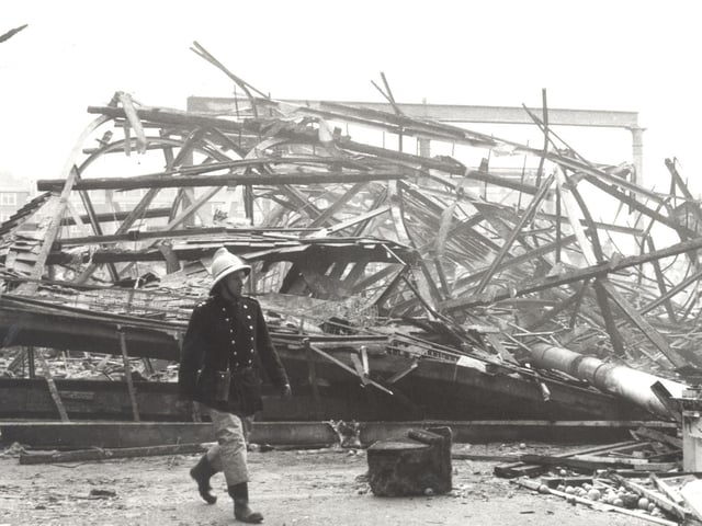 A firefighter walks past the devastation.