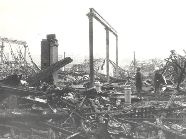 Council chiefs wearing hard hats survey the damage.